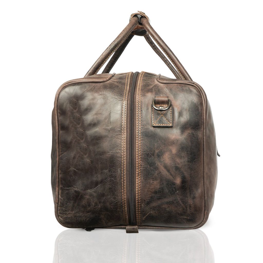 Minori Leather Riley brown leather duffle bag with sturdy handles and spacious main compartment for travel and weekend use.